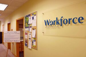 Hallway with “Workforce Development, Inc.” sign and bulletin boards featuring job and event postings at a Workforce Development Center Minnesota.