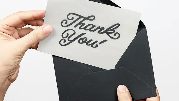 Hands opening a thank you card